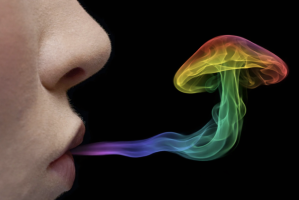 Close-up of a face blowing out colorful smoke against a black background, where the smoke is shaped like a mushroom.